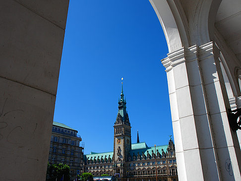 Blick durch die Bögen der Alster Arkaden auf das Rathaus